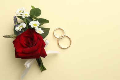 Photo of Small stylish boutonniere and rings on beige background, flat lay. Space for text