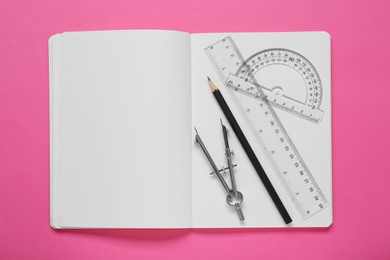 Rulers, compass, pencil and notebook on pink background, flat lay