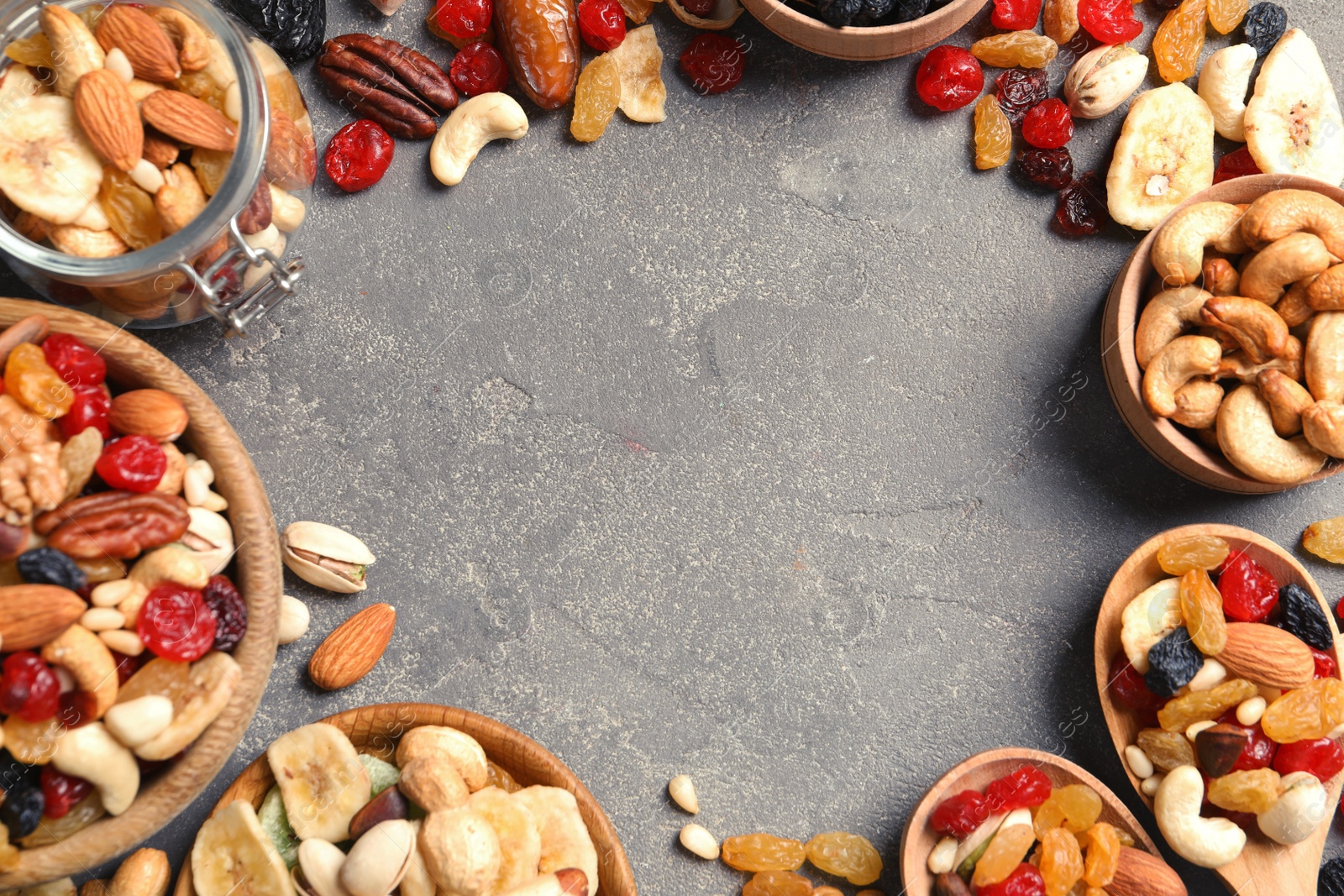 Photo of Frame of different dried fruits and nuts on color background, top view. Space for text
