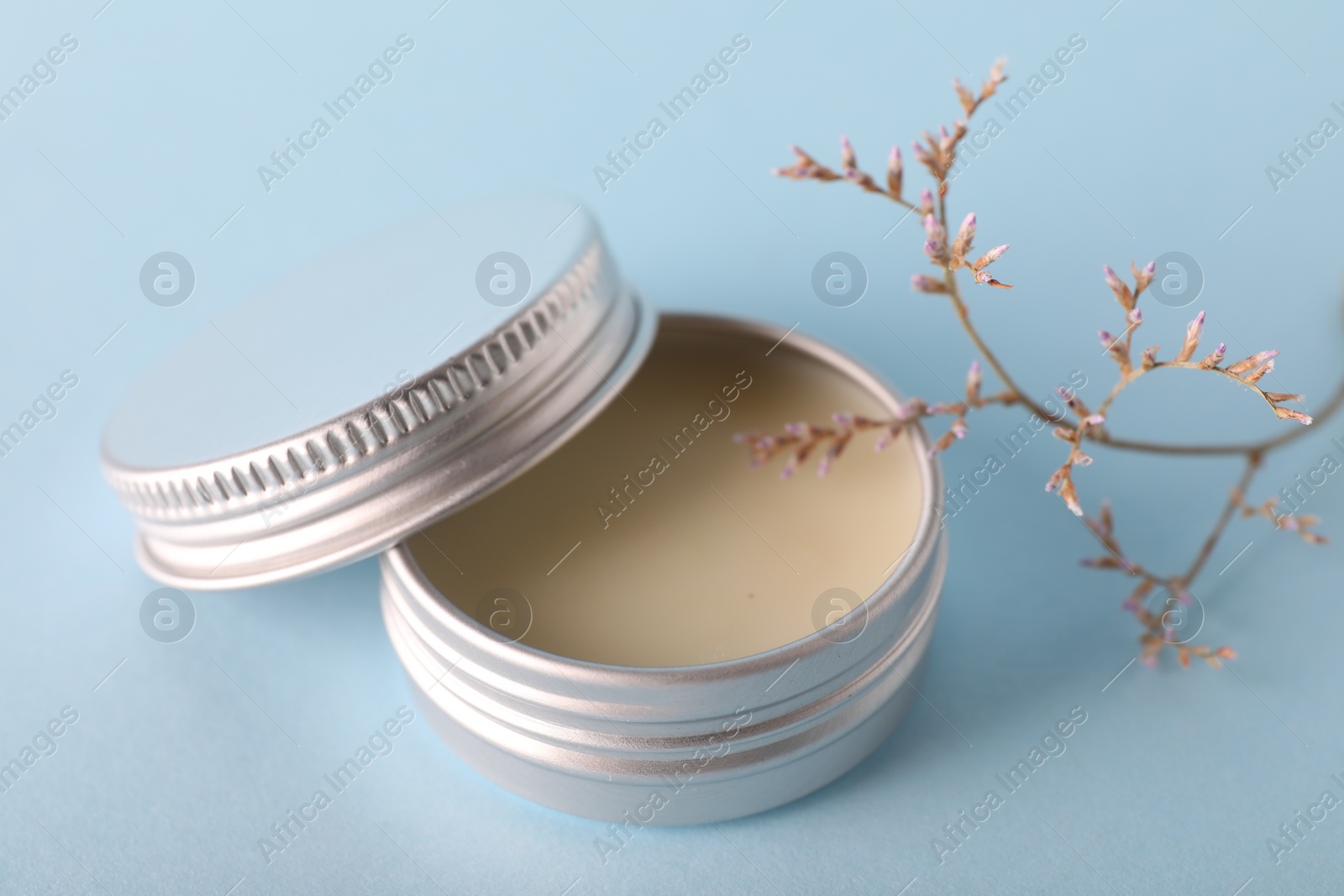 Photo of Lip balm on light blue background, closeup