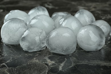 Many frozen ice balls on black marble table, closeup