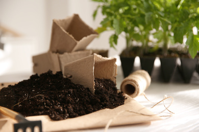 Photo of Peat pots, rope, soil and blurred seedlings on background