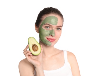 Young woman with clay mask on her face holding avocado against white background. Skin care