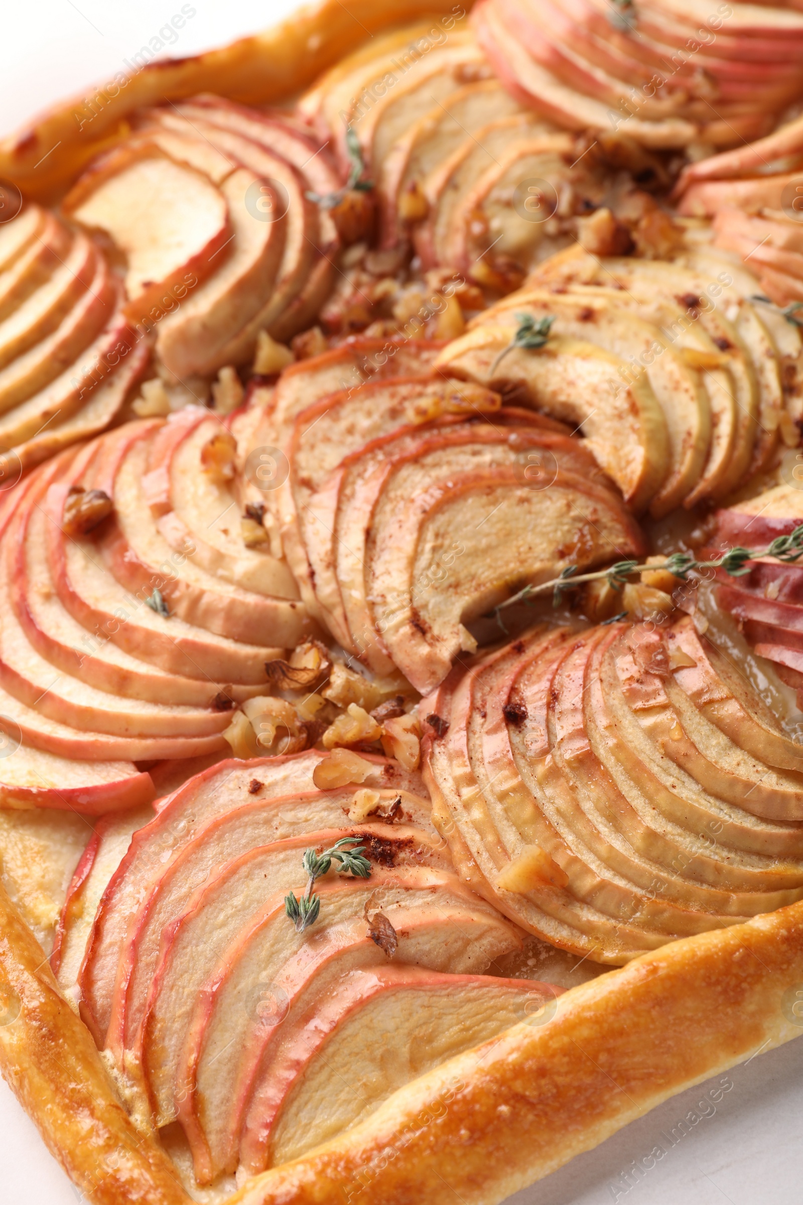 Photo of Freshly baked apple pie with nuts on white table, closeup
