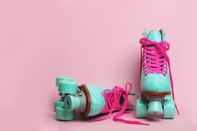 Photo of Pair of stylish quad roller skates on color background. Space for text