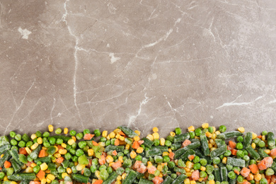 Photo of Frozen vegetable mix on brown marble table, top view. Space for text
