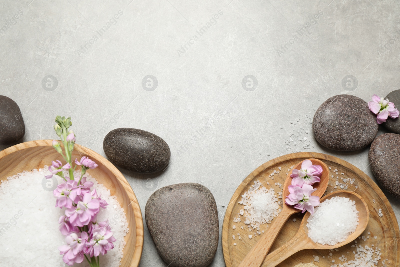 Photo of Flat lay composition with sea salt and spa stones on grey marble table. Space for text