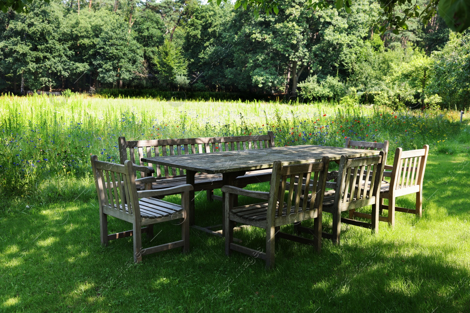 Photo of Empty wooden table with bench and chairs in garden