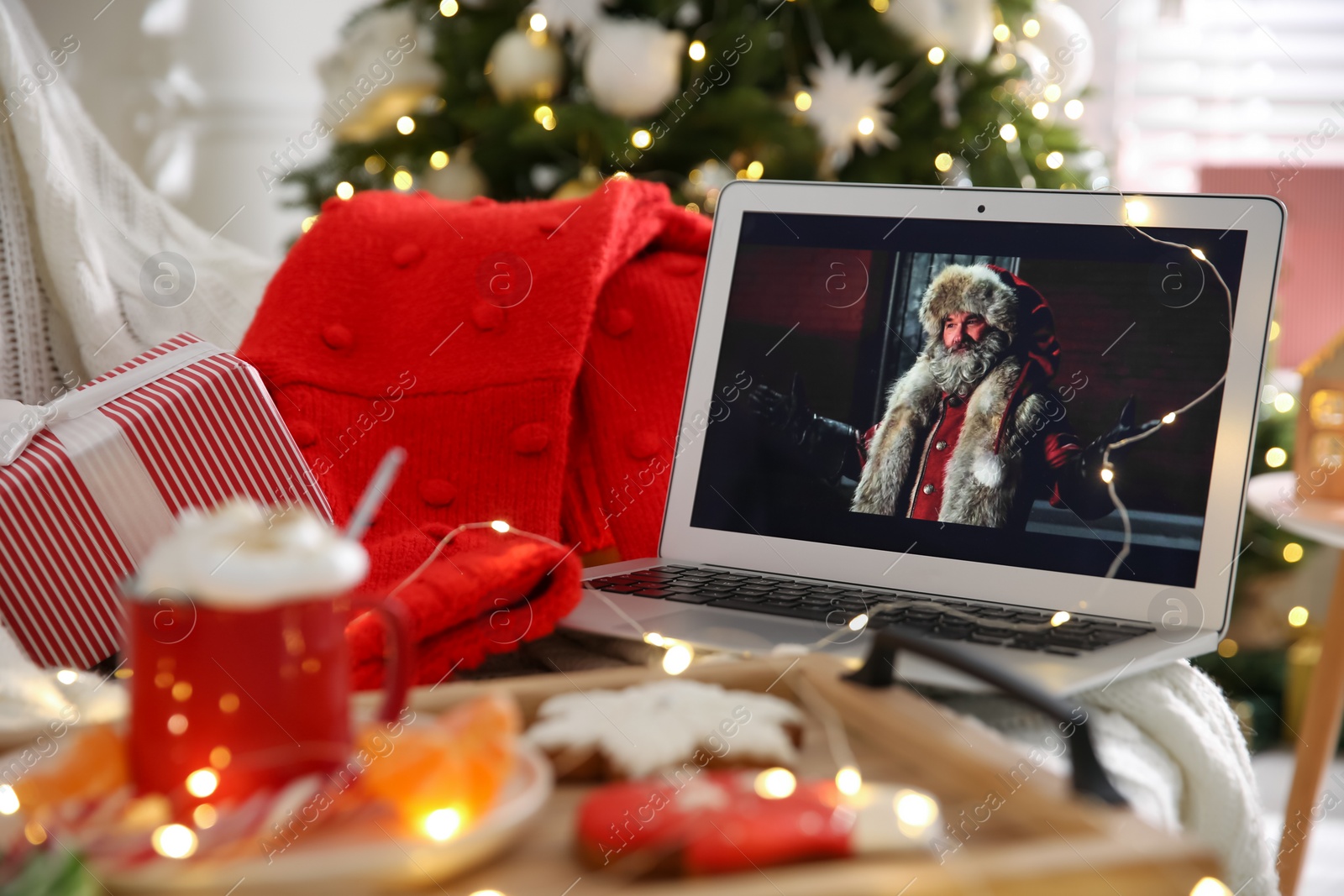 Photo of MYKOLAIV, UKRAINE - DECEMBER 25, 2020: Laptop displaying Christmas Chronicles movie at home. Cozy winter holidays atmosphere