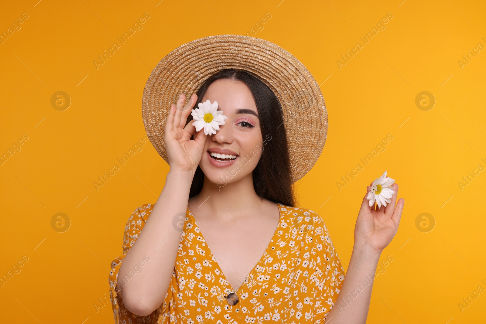 Photo of Beautiful woman with spring flowers in hands on yellow background