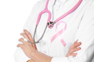 Female doctor with pink ribbon and stethoscope on white background, closeup. Breast cancer concept