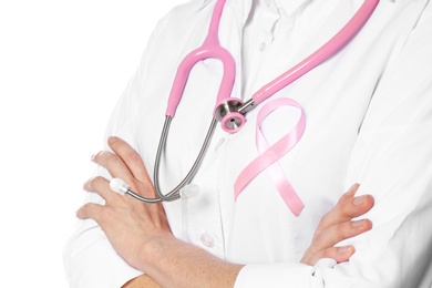 Photo of Female doctor with pink ribbon and stethoscope on white background, closeup. Breast cancer concept