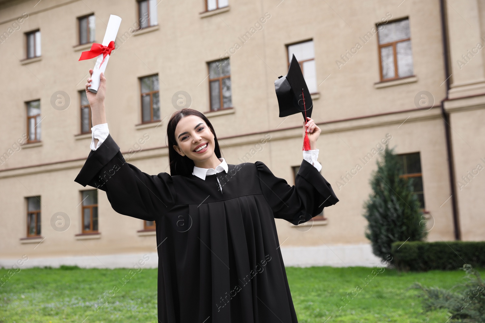 Photo of Happy student with diploma after graduation ceremony outdoors