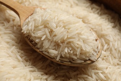 Photo of Raw basmati rice and wooden spoon, closeup