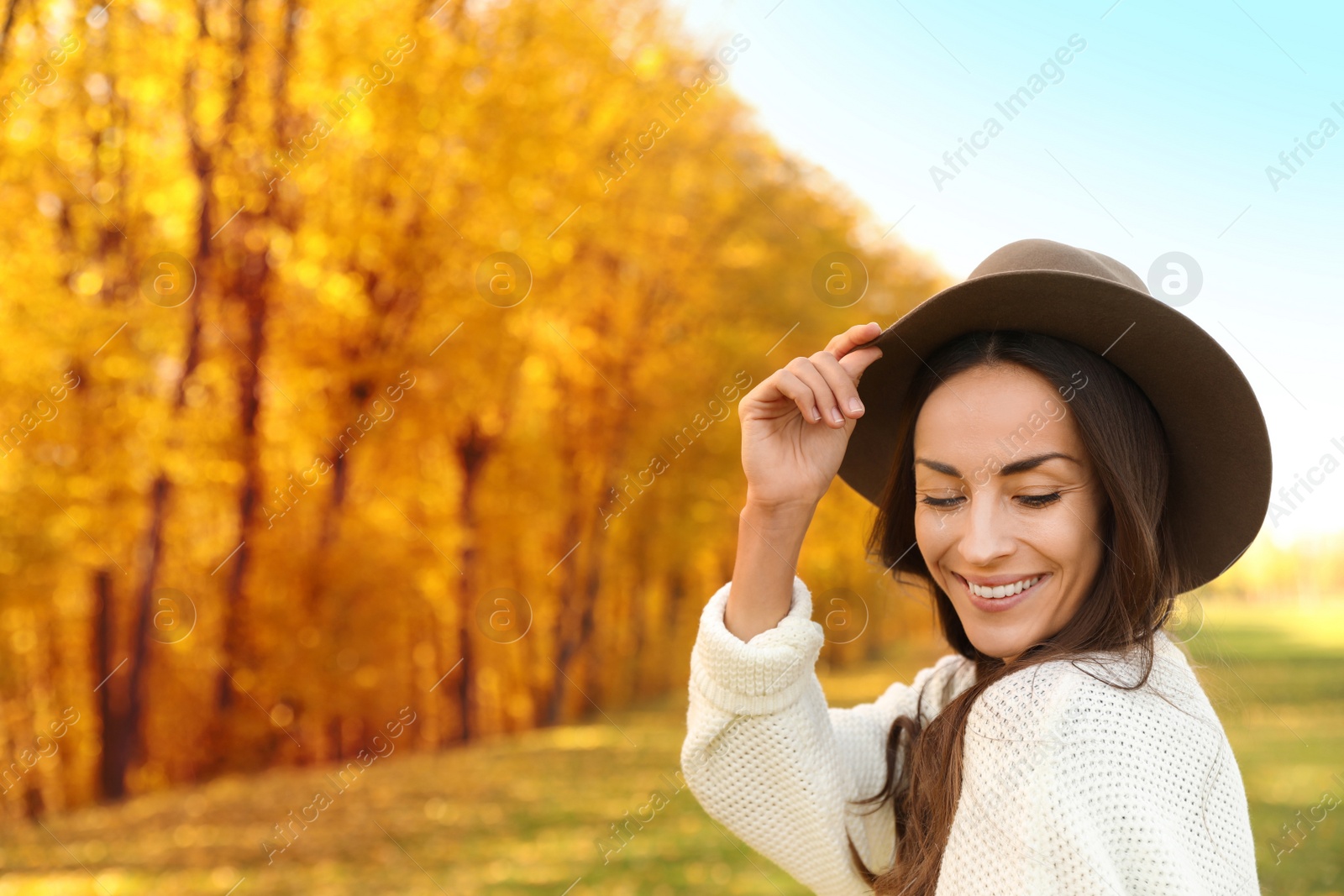 Photo of Beautiful happy woman wearing hat in park. Autumn walk