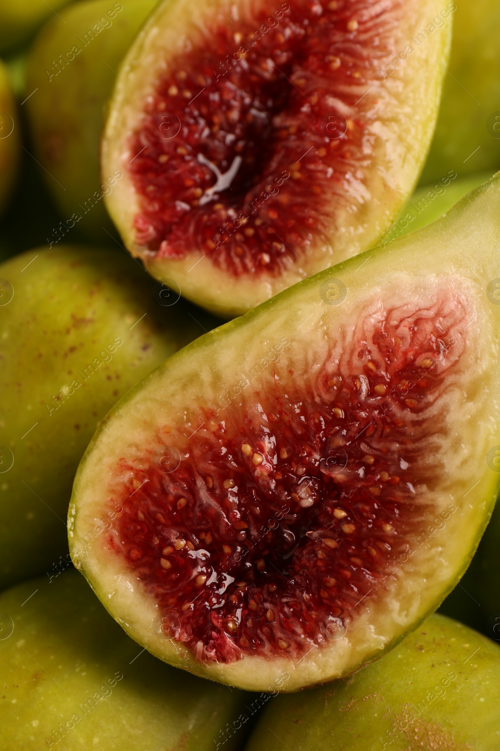 Photo of Halves of green fig on fresh fruits, closeup