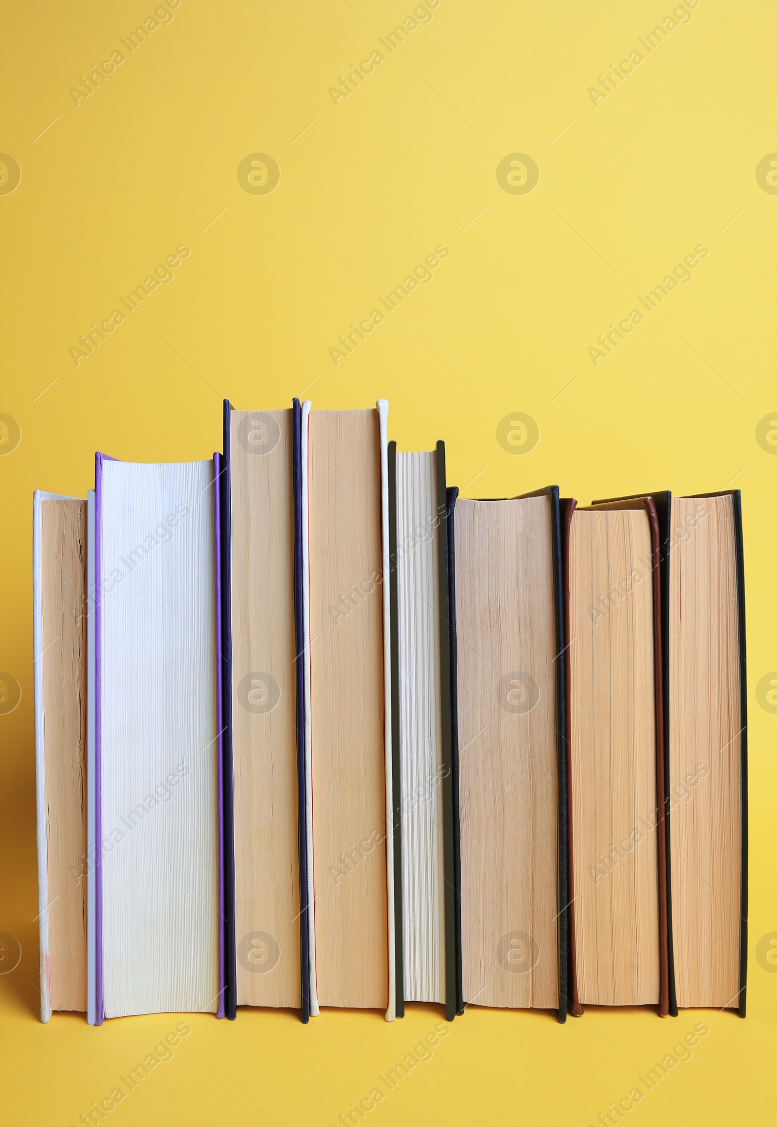 Photo of Collection of hardcover books on yellow background