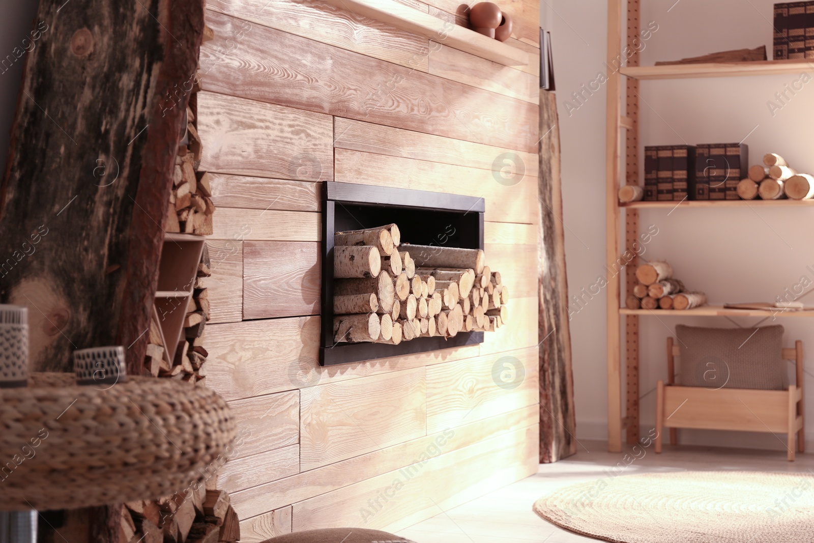 Photo of Decorative fireplace with stacked wood in cozy living room interior