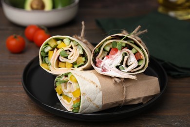 Delicious sandwich wraps with fresh vegetables on wooden table