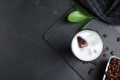 Photo of Glass of milk with delicious grass jelly and coffee beans on black table, flat lay. Space for text