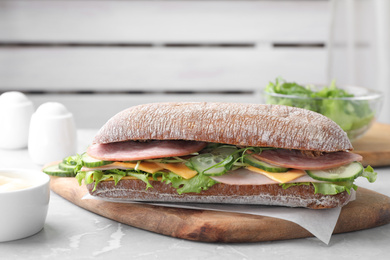 Photo of Tasty sandwich with ham served on grey kitchen table