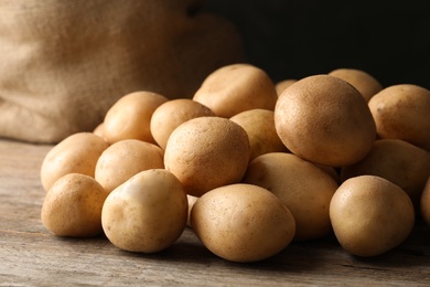 Raw fresh organic potatoes on wooden table