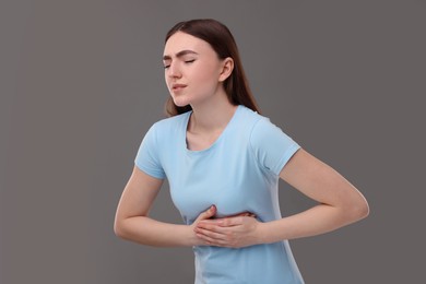 Woman having heart attack on grey background