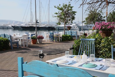 Photo of Beautiful view of outdoor cafe with tables near pier