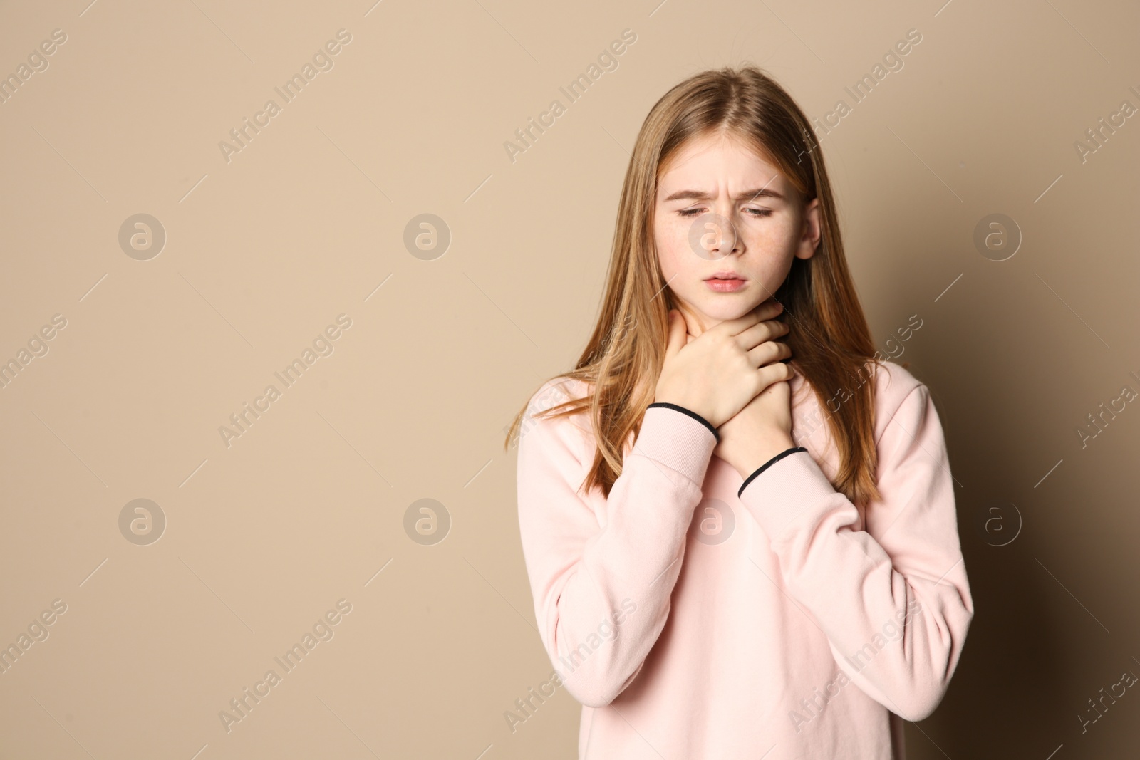 Photo of Teenage girl suffering from cough on color background. Space for text