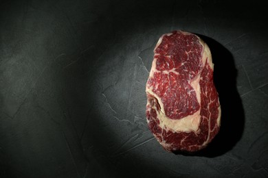 Piece of raw beef meat on grey table, top view. Space for text