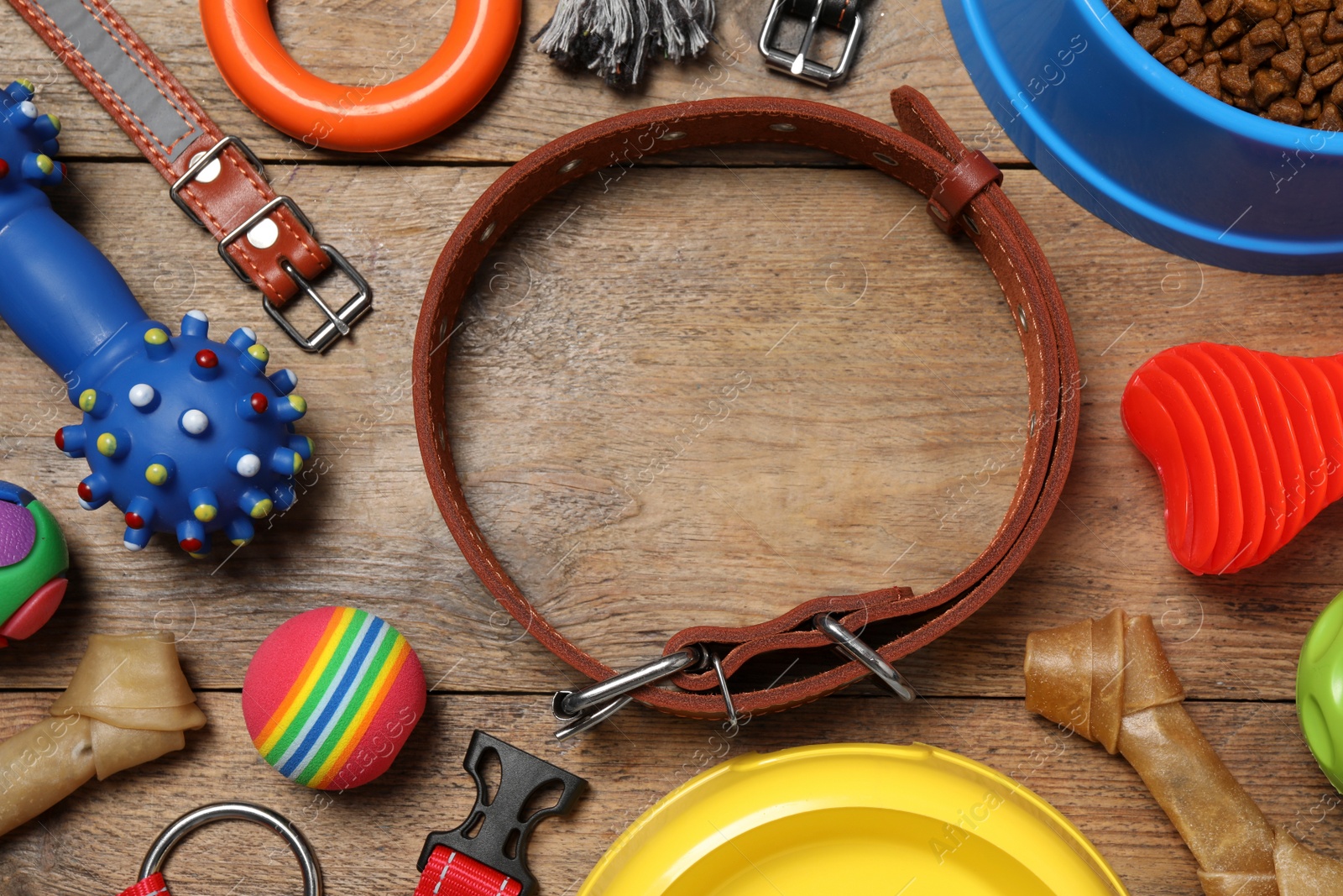 Photo of Flat lay composition with dog collar, toys and food on wooden table