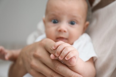 Photo of Father with his cute baby at home, focus on hands