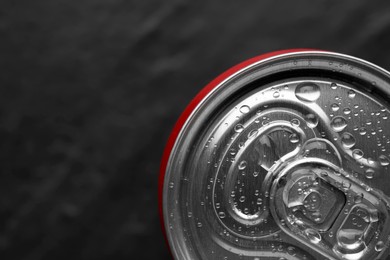 Photo of Energy drink in wet can on black textured background, top view. Space for text