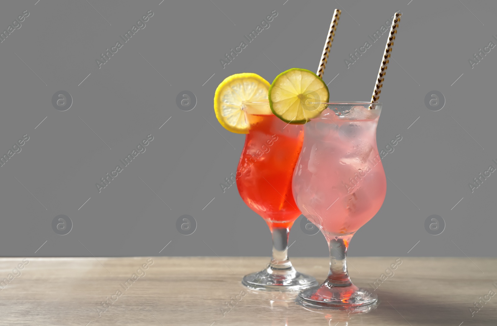 Photo of Delicious refreshing drinks on grey table. Space for text