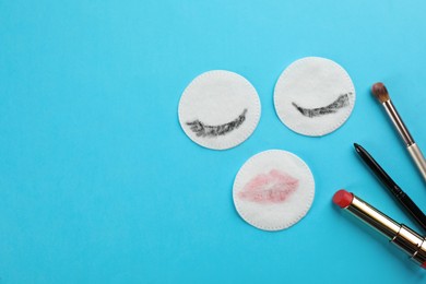 Photo of Dirty cotton pads, brush and cosmetic on turquoise background, flat lay. Space for text