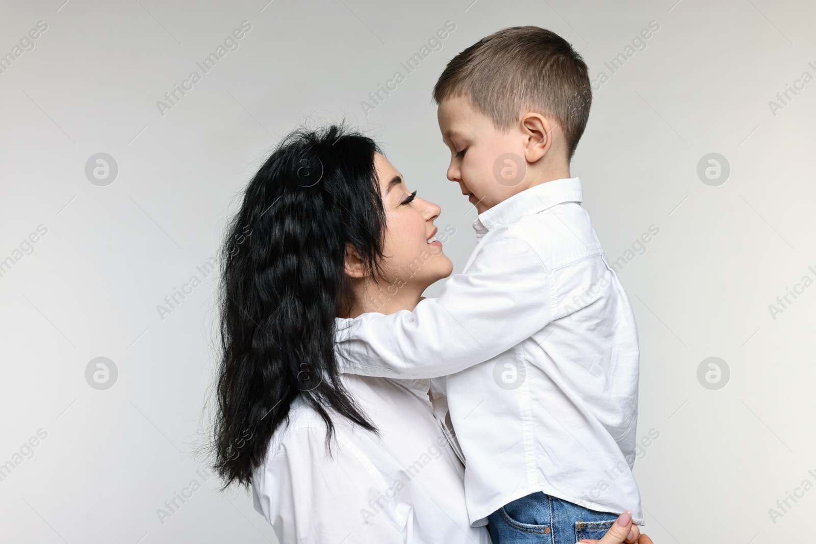 Photo of Beautiful mother hugging little son on white background
