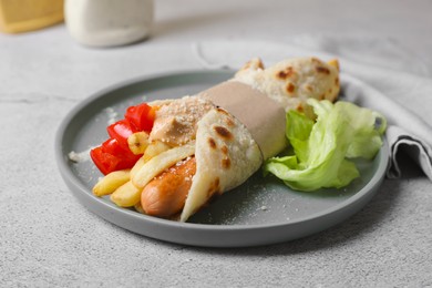 Photo of Delicious pita wrap with sausage, french fries and vegetables on light gray table