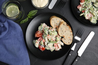 Photo of Delicious salad with mayonnaise served on black table, flat lay