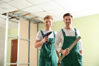 Photo of Construction workers in uniforms indoors. Home repair service
