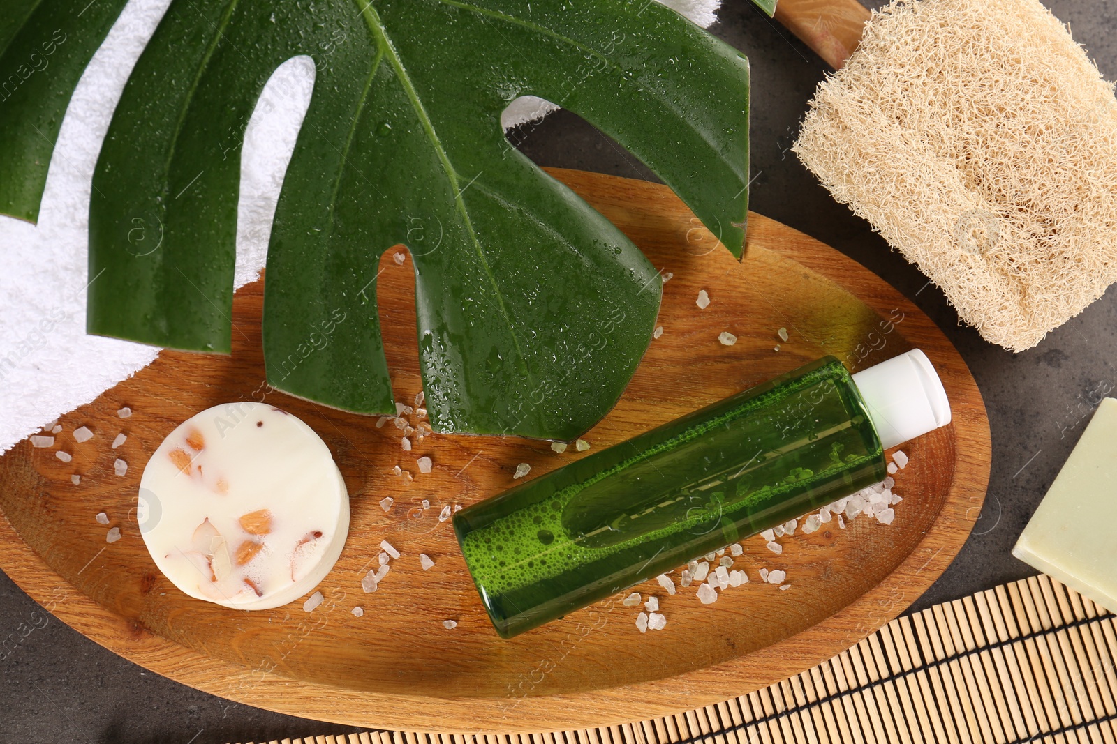 Photo of Card with word Retreat, different spa products and green palm leaf on textured table, flat lay