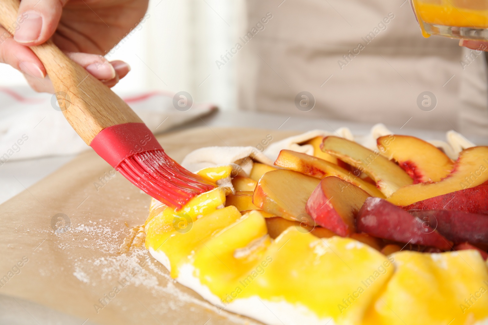 Photo of Woman making peach pie at kitchen table, closeup