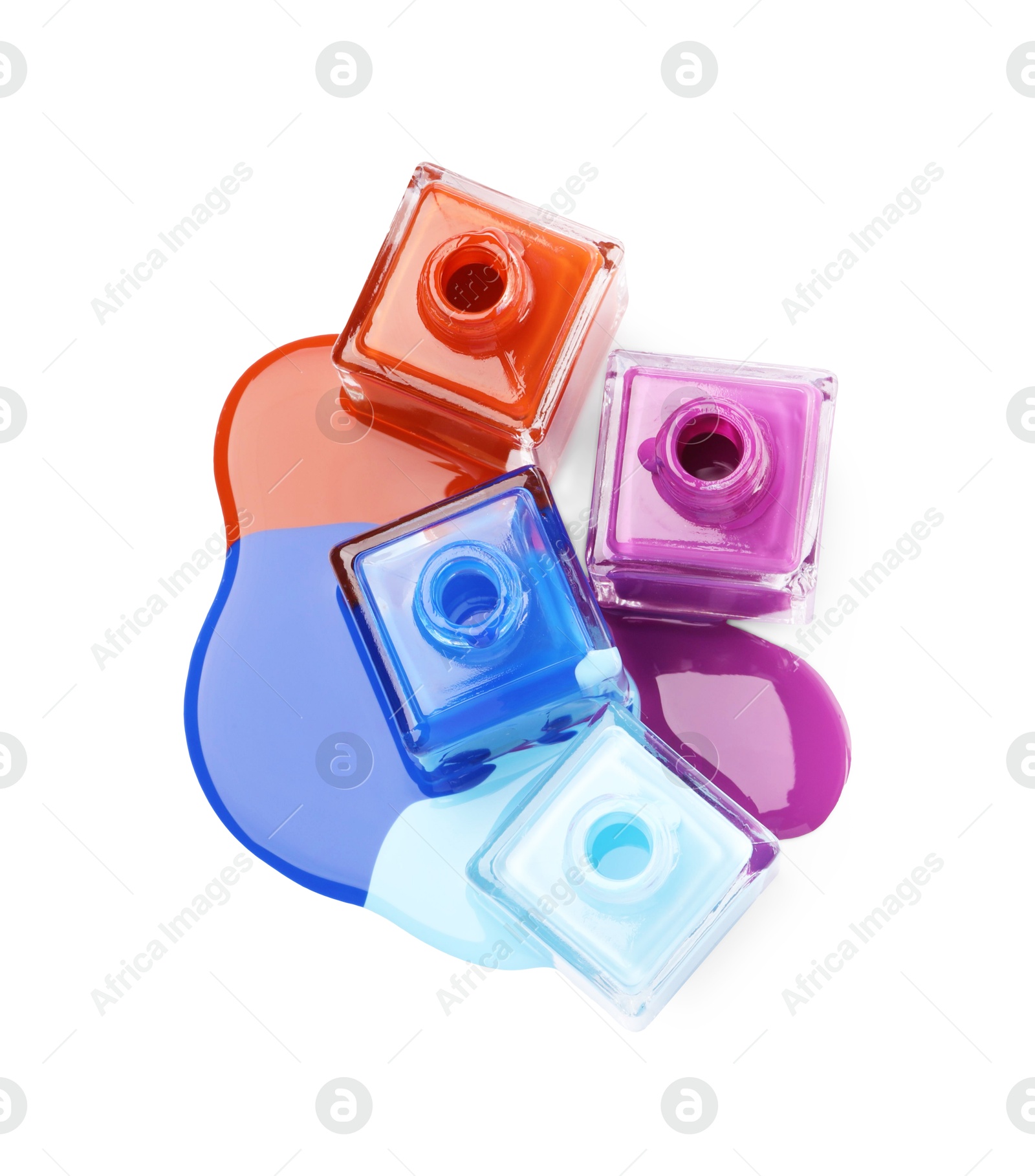 Photo of Puddle of different bright nail polishes and bottles isolated on white, top view