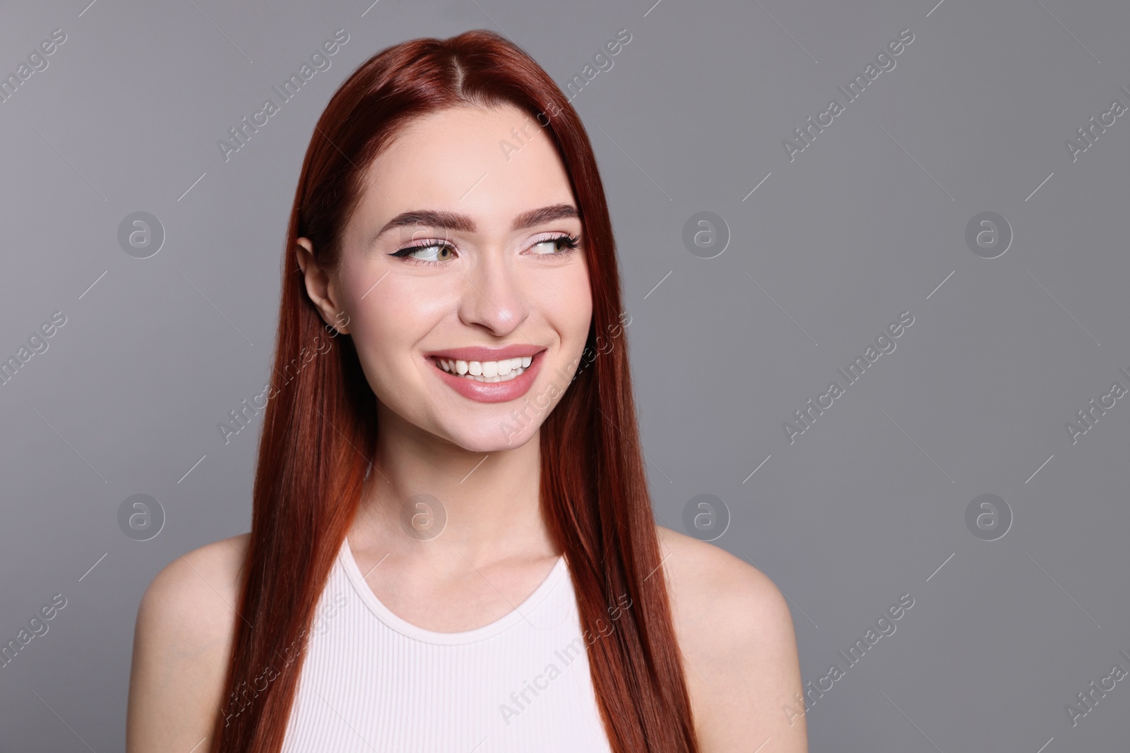 Photo of Happy woman with red dyed hair on light gray background. Space for text