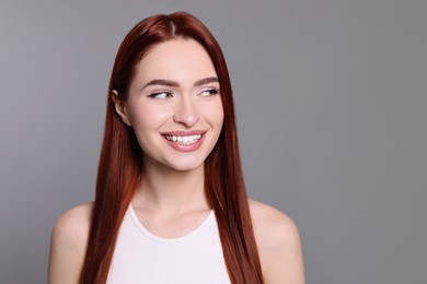 Photo of Happy woman with red dyed hair on light gray background. Space for text