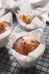 Delicious muffins with powdered sugar on light table, closeup