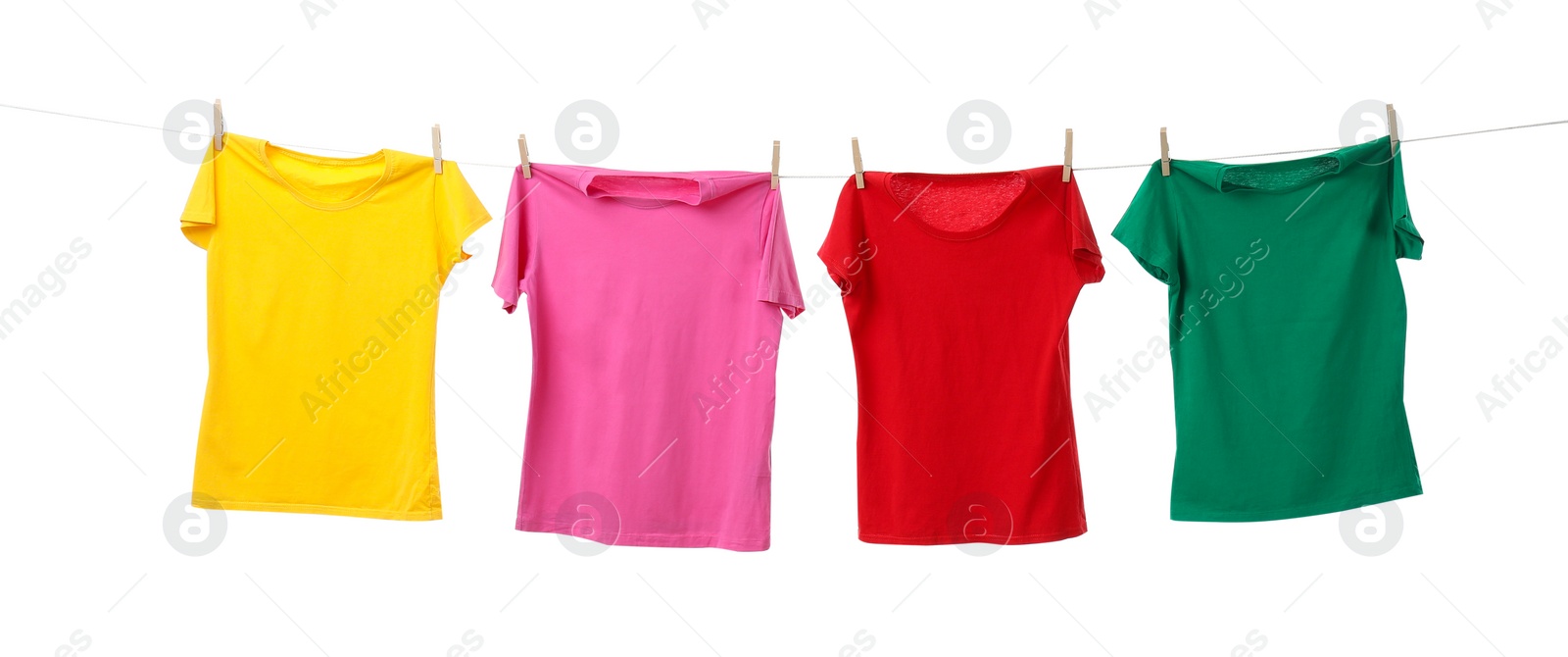 Photo of Different bright t-shirts drying on washing line against white background