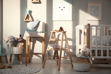 Photo of Beautiful baby room interior with stylish wooden ladder