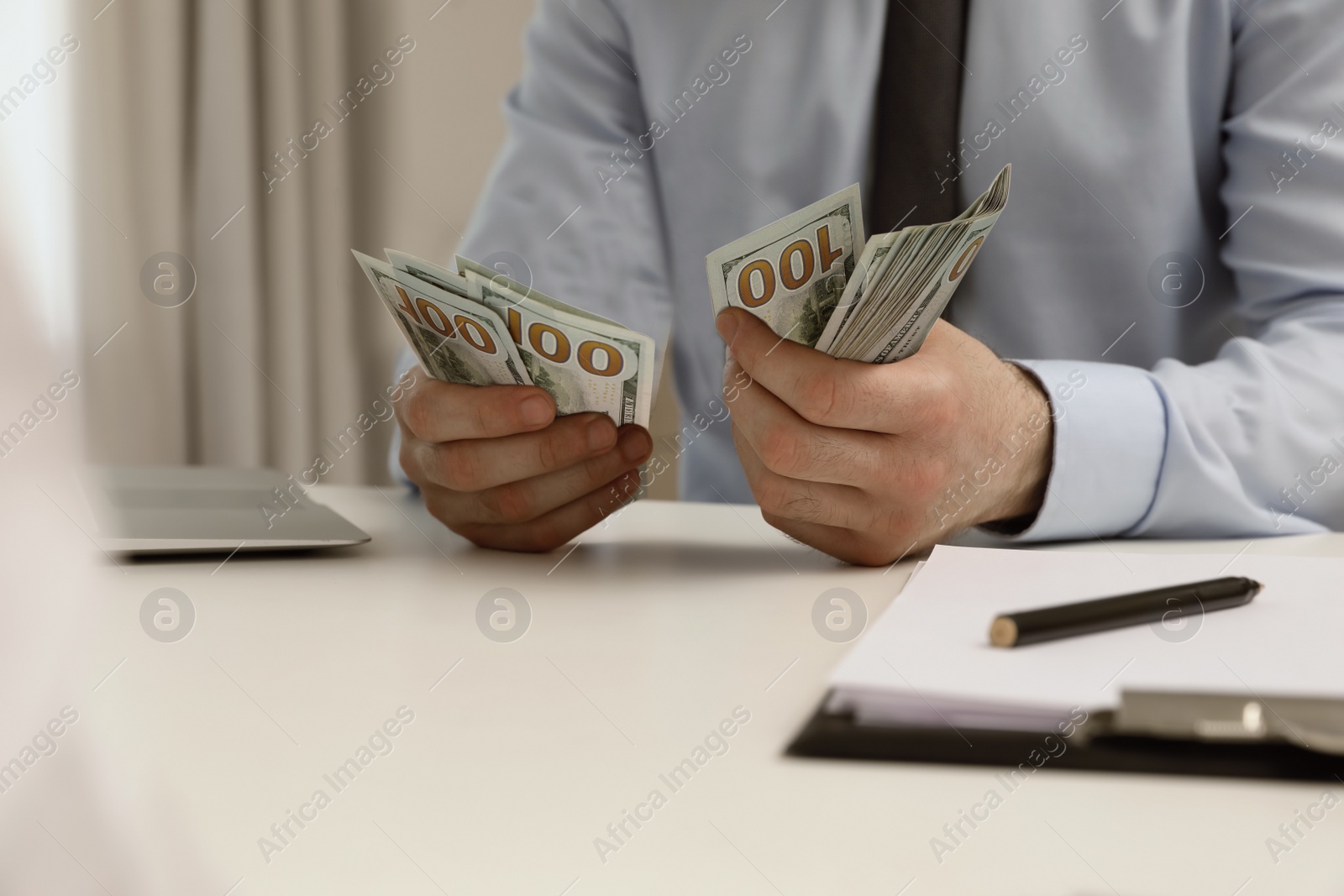 Photo of Cashier counting money at desk in bank, closeup