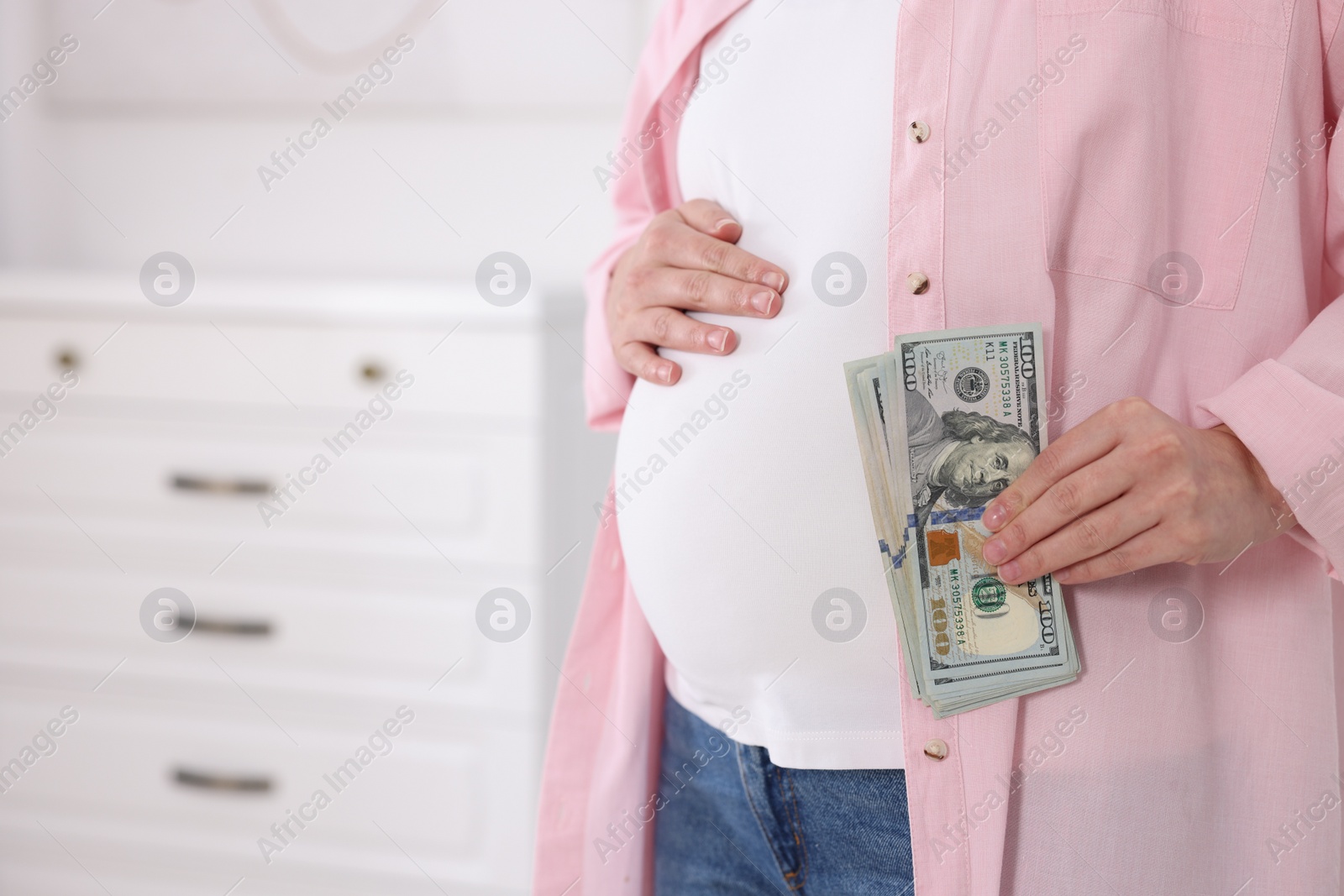 Photo of Surrogate mother. Pregnant woman with dollar banknotes indoors, closeup. Space for text