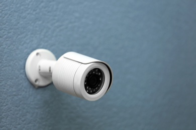 Photo of Modern security CCTV camera on grey wall